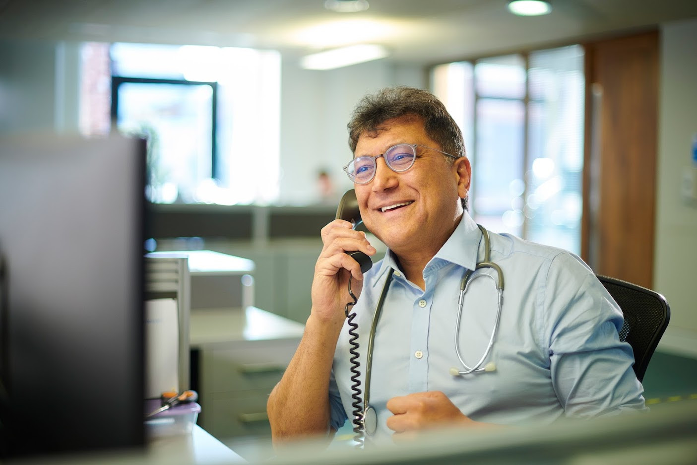 Male doctor chatting on phone.