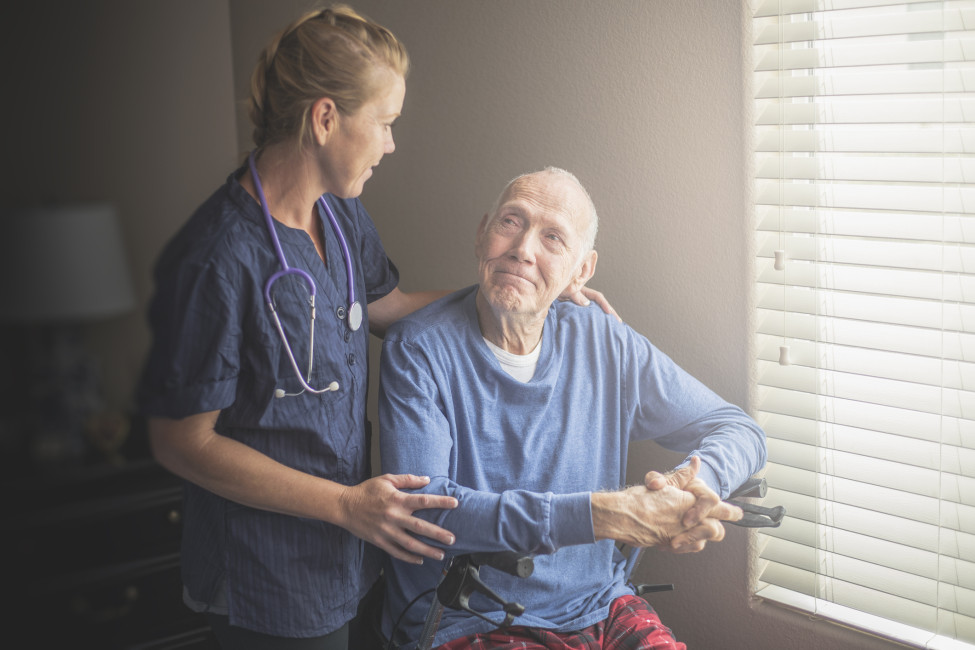 Nurse comforting elderly patient.