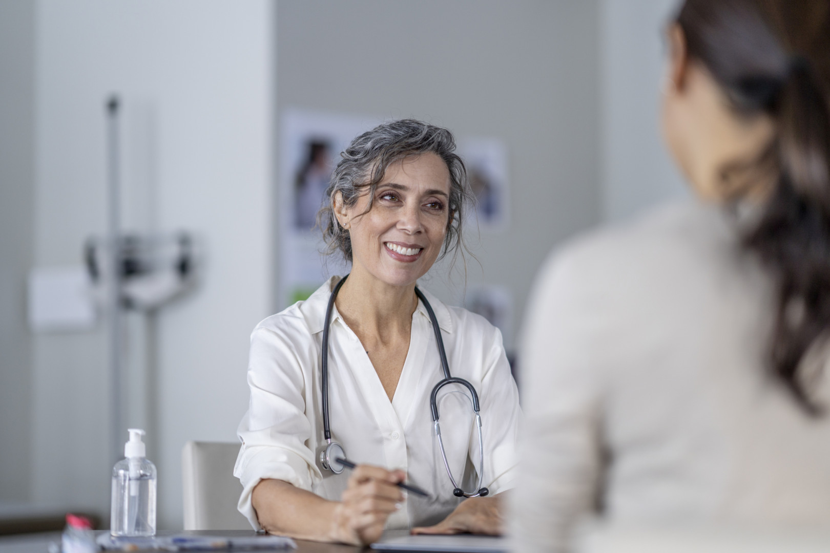 General practitioner smiling whilst speaking with a patient