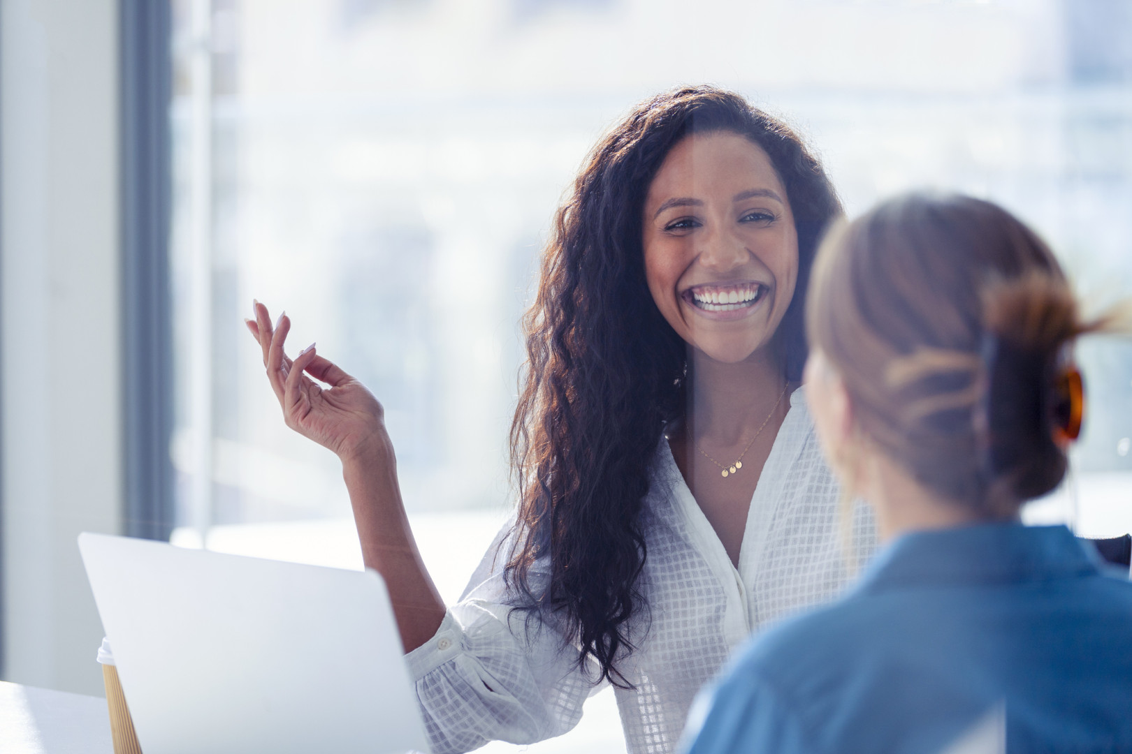 Woman smiling and talking to colleague.