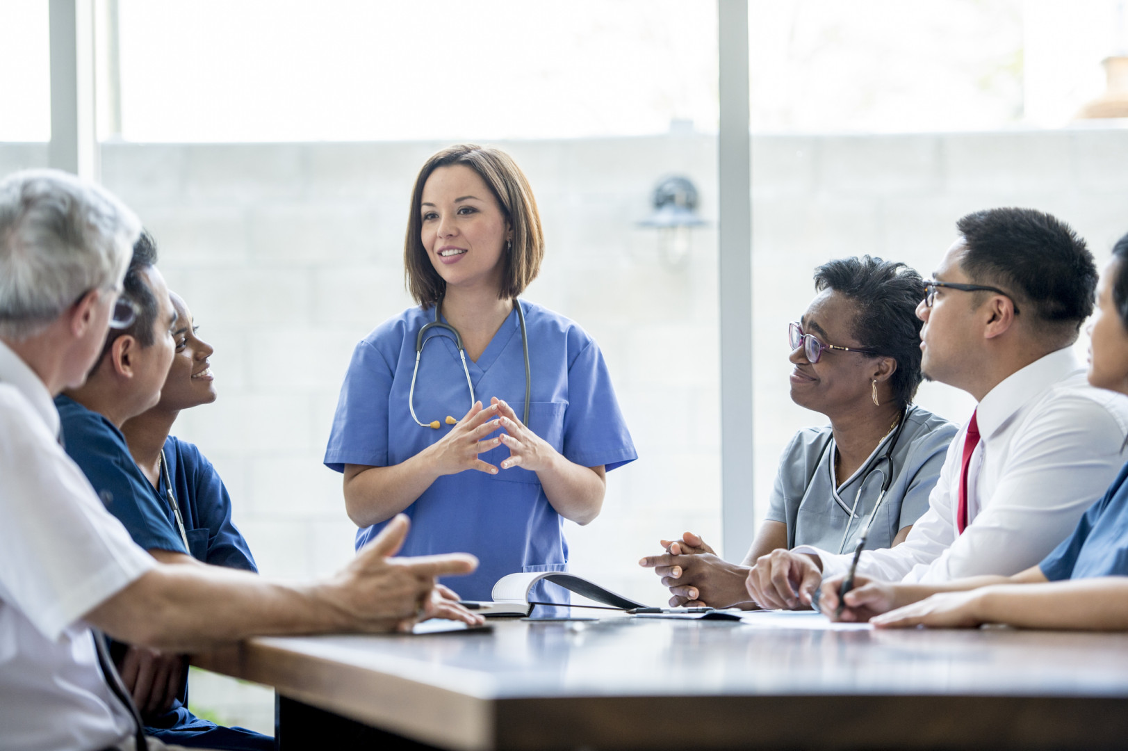 Health professionals talking at a meeting.